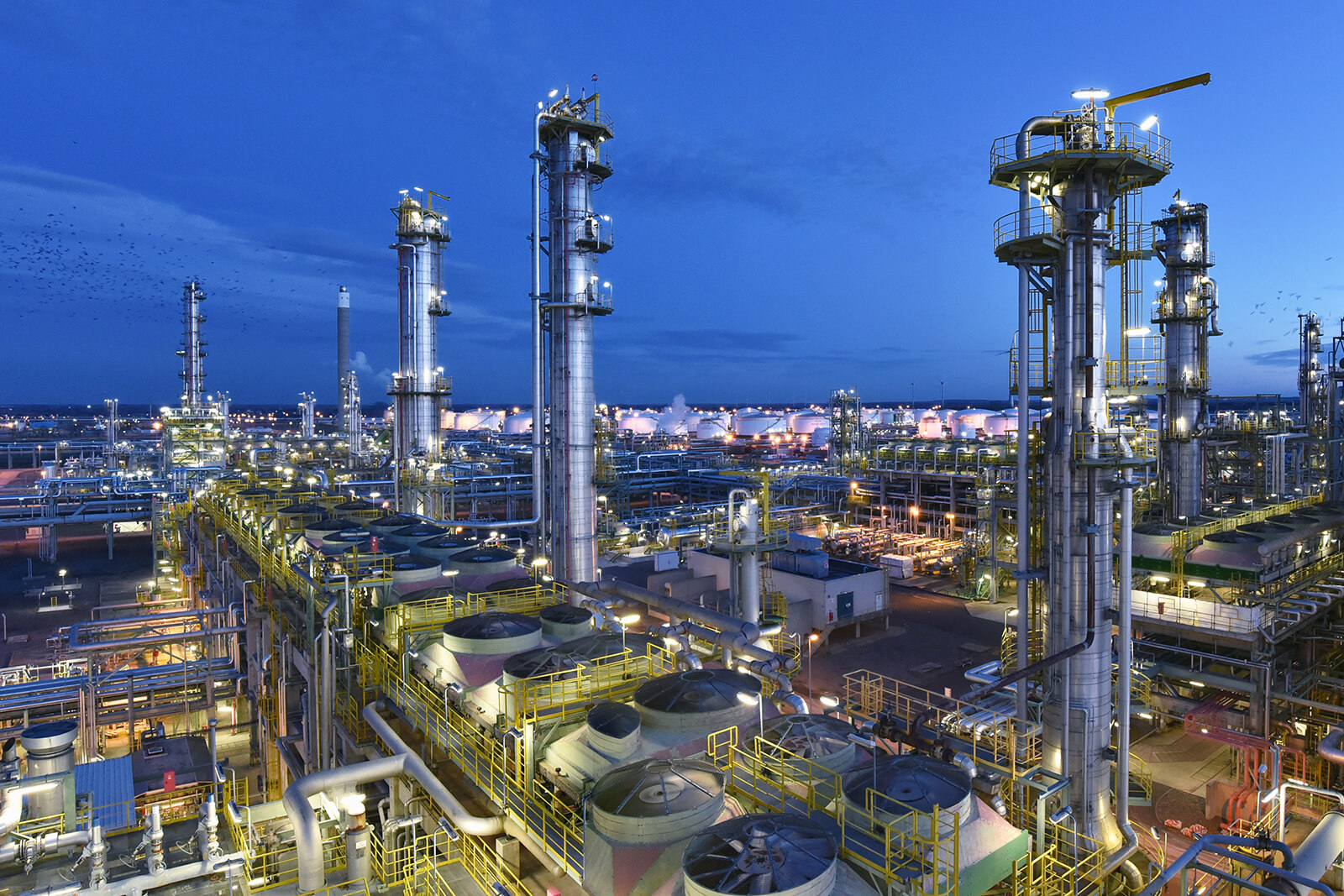 Industrial plant petrochemical processing refinery at night - production and processing of crude oil.