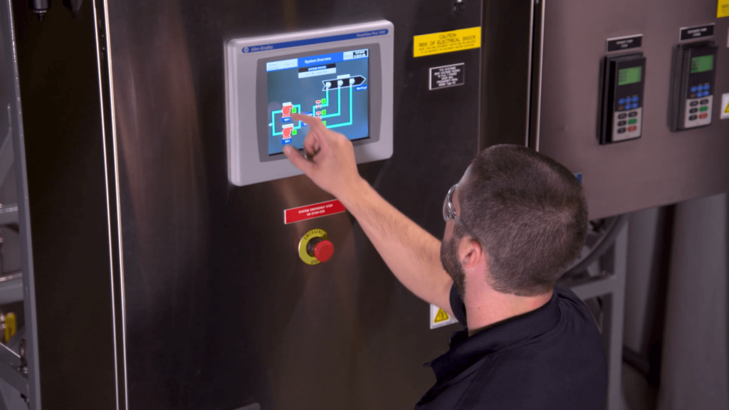 Still from BETE’s Custom Spray Systems Solutions Video showing an engineer operating an automated spray system control panel