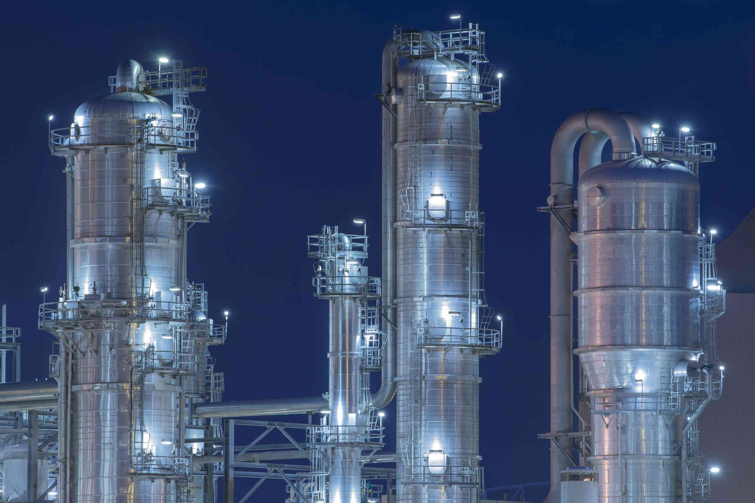 Image of chemical processing equipment throughout a refinery plant taken at night